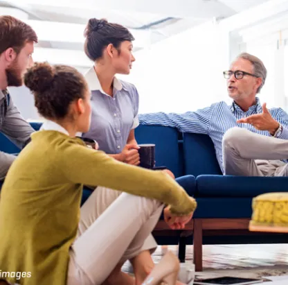Quatre personnes sur et autour de la chaise discutant de quelque chose.